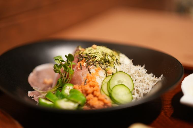 A rice bowl topped with whitebait and vegetables