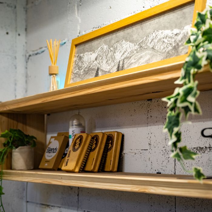 A framed drawing of the Hakuba range on a timber shelf, with ski wax and brushes below