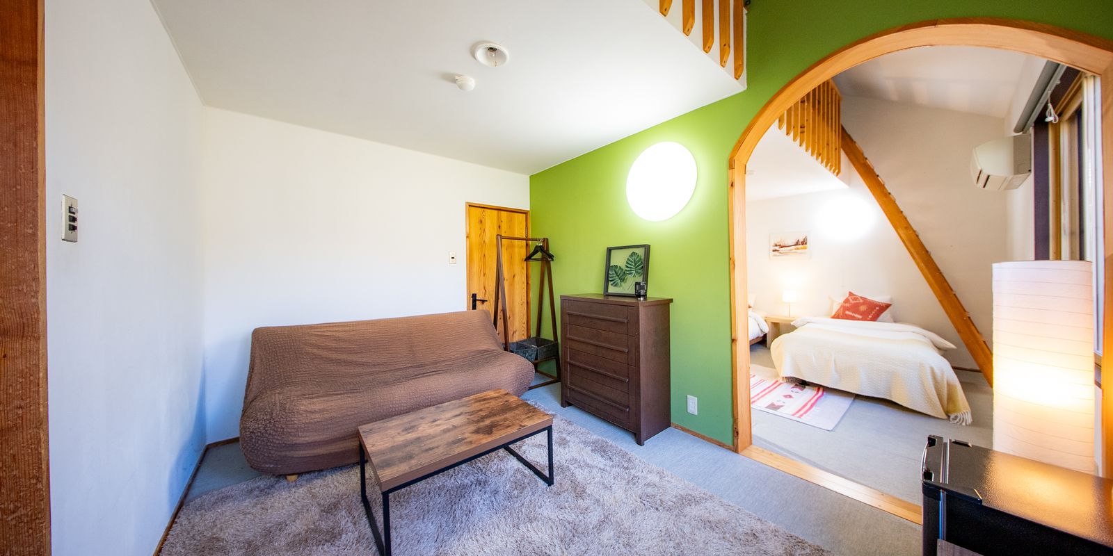 The Family Suite, a sitting area opening through a timber arch into the bedroom