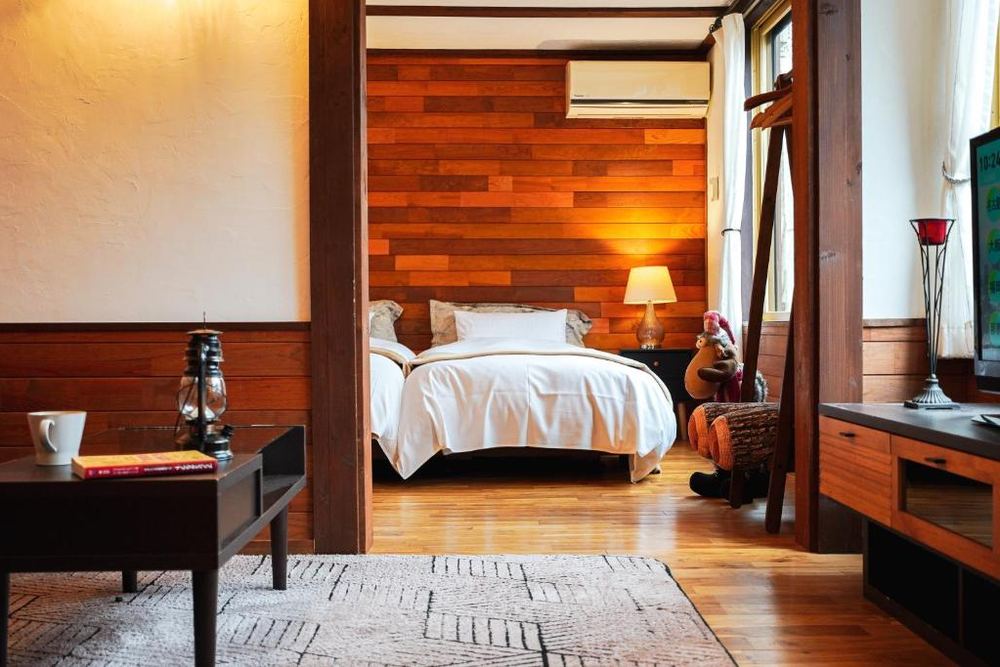 The Suite, white bed against a timber plank wall