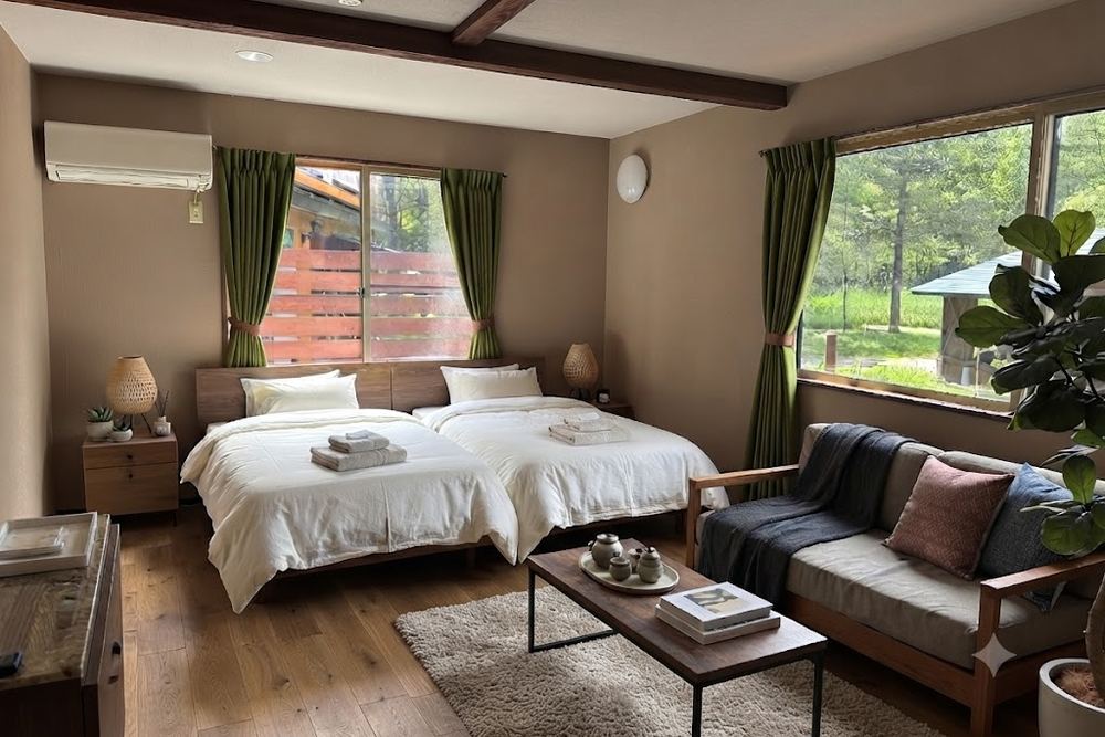 The Superior room, twin beds and a sofa with green curtains